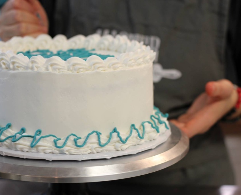 Muffin Top Bakery decorating a gluten free cake order